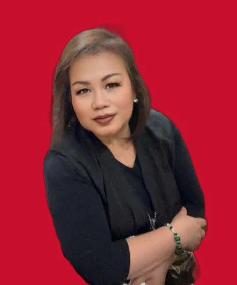 Tessie Ablazo, smiling with her arms crossed, wearing black.