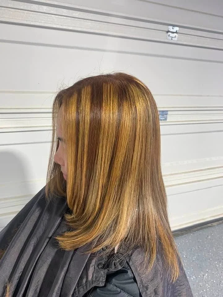 Sleek, straight hair with bold caramel and golden highlights.