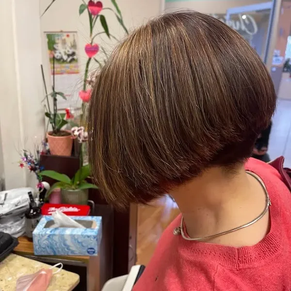 A sharp, stacked short bob with warm highlights.