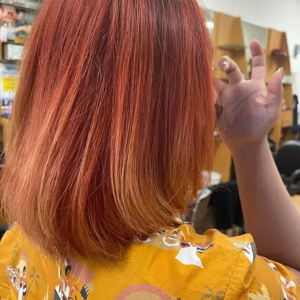 Shoulder-length hair colored a vivid copper red.